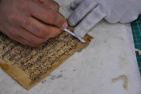 روضہ حضرت عباس(ع) میں قدیم ترین قرآنی نسخے کی مرمت + تصاویر